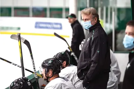  ?? Jeff Toates/Dallas Stars via AP ?? ■ Interim Dallas Stars head coach Rick Bowness watches practice Tuesday in Frisco, Texas. Bowness, 65, coached from behind the bench the first couple of days of Dallas Stars training camp before lacing up his skates and getting on the ice. Montreal's 60-year-old Claude Julien, Edmonton's 58-year-old Dave Tippett and others are confident in the NHL's protocols as older, more at-risk people during the COVID-19 pandemic.