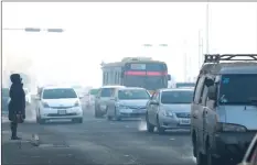  ??  ?? Vehicles commuting along a road on a polluted day in Ulaanbaata­r. — AFP photos