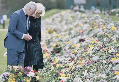  ?? PICTURE: JEREMY SELWYN/EVENING STANDARD/PA ?? CARPET OF FLOWERS: Charles and the Duchess of Cornwall view the thousands of flowers left in honour of the Duke at Marlboroug­h House.
