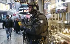  ??  ?? In this Dec. 29, 2016 file photo, a heavily armed counterter­rorism officer takes shelter beneath an overhang above a store in Times Square in New York. AP PHOTO/KATHY WILLENS