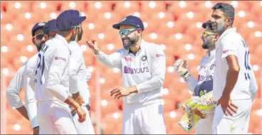  ?? PTI ?? Indian captain Virat Kohli gestures at Axar Patel as R Ashwin (R) and Rishabh Pant look on during the third day of the 4th and last cricket test match against England in Ahmedabad on Saturday. The hosts thumped the visitors by an innings and 25 runs inside three days to complete the 3-1 series victory.