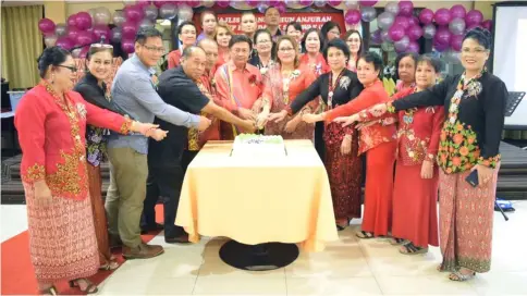  ??  ?? Mawan (front row, sixth left) leads event organising committee members and others in cutting a cake to mark the occasion.