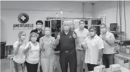  ?? COURTESY OF JOHN LANGLOIS ?? Virginia Beach Mayor Bobby Dyer, center, stands with employees inside Premium-PPE’s facility, where they’ve been producing AmeriShiel­d masks since March in Virginia Beach.