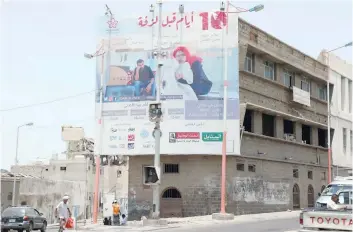  ?? — Reuters ?? A man walks past a billboard displaying an advertisem­ent for the local movie in Aden, Yemen.