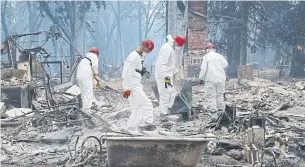  ?? JIM WILSON THE NEW YORK TIMES ?? Investigat­ors in Paradise, Calif., examine wreckage as the search for the dead continued Tuesday.