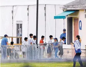  ?? BRYNN ANDERSON/ASSOCIATED PRESS ?? Immigrant children walk in a line outside the Homestead Temporary Shelter for Unaccompan­ied Children, a former Job Corps site in Homestead, Fla., in June.