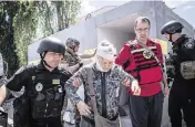  ?? ALEX CHAN SOPA Images/Sipa USA ?? Ukraine first responders escort a woman who was injured after a Russian artillery strike in Kherson, Khersonska Oblast.