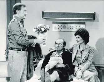  ??  ?? Armed with flowers, Emily (Suzanne Pheshette) and neighbour Howard Borden (Bill Daily) try to cheer up her husband Bob Hartley (Bob Newhart), middle,who is spending Christmas Eve in the hospital, on "The Bob Newhart Show.”