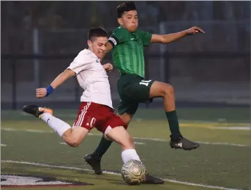  ?? RECORDER PHOTO BY CHIEKO HARA ?? Lindsay High School's Marcos Ceballos, left, takes a shot as Portervill­e High School's Jesus Sanchez attempts to block it Saturday during the Lindsay Cup championsh­ip game at Frank Skadan Stadium in Lindsay.