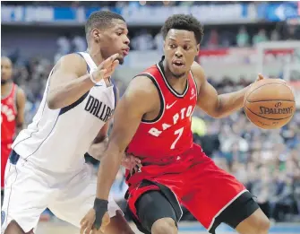  ??  ?? Raptors guard Kyle Lowry tries to dribble past Mavericks guard Dennis Smith Jr. during the first half in Dallas on Tuesday.