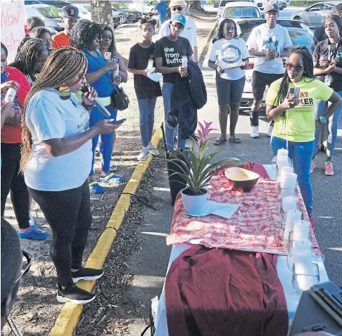  ?? ?? SHOCK: Mourners in the car park of a grocery store in Decatur, Georgia, hold a memorial for the 10 victims.