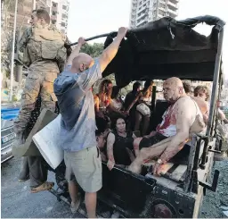  ??  ?? Injured people are transporte­d by soldiers away from the scene of the blast.
