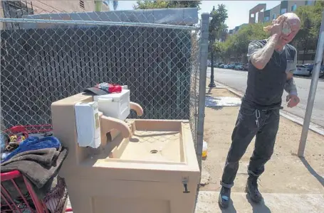  ?? John Gibbins Associated Press ?? JAIME LYNN HINES washes his face at one of the hand-washing stations installed by San Diego County in an attempt to halt the spread of the hepatitis A virus. The outbreak has continued to grow, killing 16, hospitaliz­ing 292 and infecting 421, according...