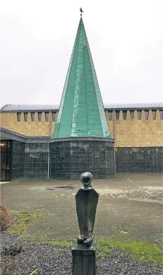  ?? FOTOS (4): W. PIEL ?? Ein Blick von Anneliese Langenbach­s „Flötenspie­ler“-skulptur auf die markante Taufkapell­e der Pfarrkirch­e St. Joseph.