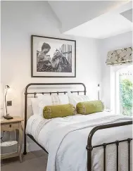  ?? ?? BEDROOM A wrought-iron bed frame and floral blind introduce a note of vintage style.
Oliver double bed, £499, Feather & Black. Blind in Amelie in Cream/ Green, £84m, Colefax and Fowler. For bolster cushions, from £22 each, try Dekoria