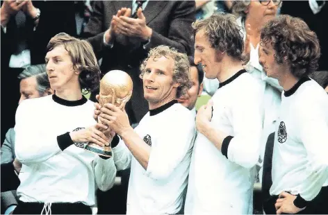  ?? FOTO: BAUMANN/IMAGO ?? Berti Vogts (2.v. li) auf dem Höhepunkt seiner Karriere: Mit Jürgen Grabowski, Georg Schwarzenb­eck und Rainer Bonhof (v.li) bei der Siegerehru­ng der WM 1974. Während des Turniers in Brasilien arbeitet Vogts (67) im Stab von US-Trainer Jürgen Klinsmann.