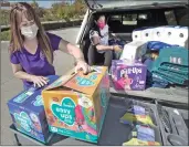  ?? Dan Watson/The Signal ?? Krysta Warfield, left, program director of the Domestic Violence of Santa Clarita Valley and Olympian Anita Alvarez load a cart of of donated items from the Purple Project at the Child & Family Center in Santa Clarita on Oct. 22.