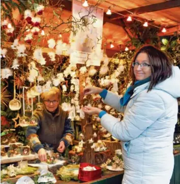  ?? Foto: Andreas Zilse ?? Monika Binder (rechts) und Ingrid Dornbracht bereiten ihren Stand auf dem Augsburger Christkind­lesmarkt vor. Wie 129 andere Beschicker sind sie gerüstet für den Besucheran­sturm.