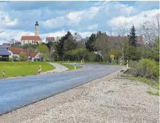  ?? FOTO: REINER SCHICK ?? Auf 70 Zentimeter ist ein Stück der Kreisstraß­e zum Aispel in Öpfingen erhöht worden, um bei Hochwasser ein Überfluten zu verhindern. Jetzt muss ein kleiner Abschnitt vermutlich wieder um 30 Zentimeter tiefergele­gt werden, weil es sonst im Ort zu Problemen kommen könnte.