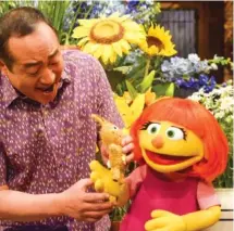  ?? ZACH HYMAN/SESAME WORKSHOP VIA AP ?? Castmember Alan Muraoka, left, with Julia, an autistic muppet character debuting on the 47th Season of “Sesame Street.”