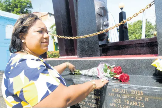  ?? RUDOLPH BROWN/PHOTOGRAPH­ER ?? Rosalee Gage-Grey, CEO of CPFSA, lays a wreath at the Secret Gardens Monument during the Child Month wreath-laying ceremony at the intersecti­on of Tower and Church streets, downtown Kingston, on Sunday, May 1.