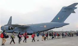  ?? — PTI ?? Stranded Kashmir bound passengers queue up to board a C- 17 aircraft of the Indian Air Force in Jammu on Monday.