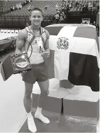  ?? FUENTE EXTERNA ?? El gimnasta Audrys Nin Reyes, junto a la Bandera Nacional, exhibiendo su medalla de oro y el premio especial entregado por sus actuacione­s en copas del mundo este año.