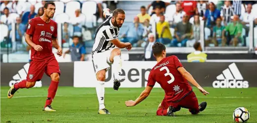  ??  ?? Hitman on target: Juventus striker Gonzalo Higuain (centre) scoring his team’s third goal in the 3- 0 win over Cagliari at the Allianz Stadium in Turin. — Reuters