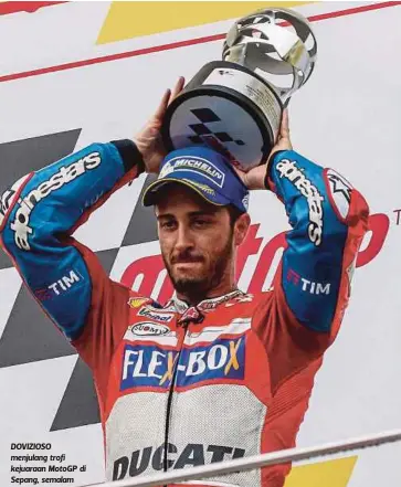  ??  ?? DOVIZIOSO menjulang trofi kejuaraan MotoGP di Sepang, semalam