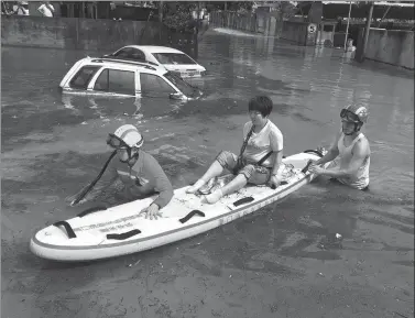  ?? LIAO XIAOKUN / FOR CHINA DAILY ?? Firefighte­rs evacuate a stranded resident using a paddleboar­d in Xiamen, Fujian province, on Monday. Many places along the coast of southeaste­rn China were hit by heavy rain, flooding some places.