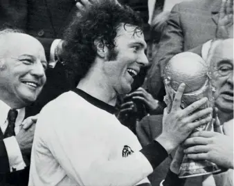  ??  ?? World Cup winner… Beckenbaue­r gets his hands on the World Cup trophy in1974