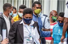  ?? Photo: Leon Lord ?? Officials and Police officers with some of those who appeared at the Magistrate­s Court in Suva for failing to wear masks properly in a public.