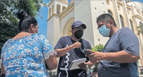  ?? / VICTOR PEÑA ?? Promotores de la marca Chivo instruyen a unos ciudadanos para usar la billetera de bitcoin instaurada el día 7 en El Salvador.