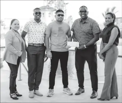  ?? ?? Azruddin Mohammed (center) hands over Team Mohamed’s contributi­on to Regatta Committee Chairman, Mr. Kenneth Williams in the presence of others