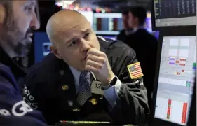  ?? Richard Drew/Associated Press ?? Specialist Mario Picone, center, works on the floor of the New York Stock Exchange. Stocks recovered from an early slide on Monday.