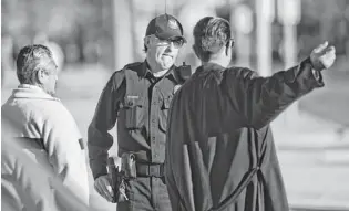  ??  ?? Police Officer Lee Williams speaks with homeless people in downtown Phoenix.