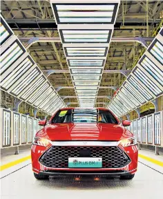  ?? ?? A Qin Plus DM-I sedan on the assembly line at BYD’S base in Changfeng County, China