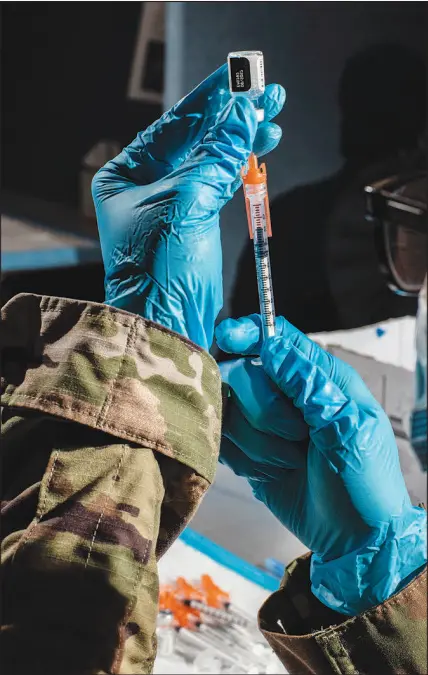  ?? BRYAN ANSELM / THE NEW YORK TIMES ?? A member of the United States military prepares doses of the Pfizer-biontech COVID-19 vaccine June 19 at New Jersey Institute of Technology in Newark, N.J. The conf lict among chiropract­ors regarding whether to recommend vaccines has become more consequent­ial as the Delta variant of the coronaviru­s spreads and the rate of new vaccinatio­ns slows.