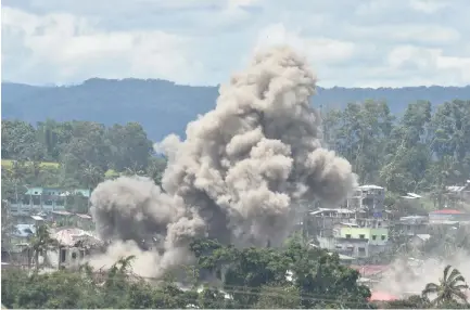  ??  ?? Black smoke billows from burning houses after Philippine airforce attack planes dropped bombs during the an aerial bombing at militants position in Marawi on Saturday. (AFP)