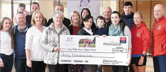  ??  ?? Friends and family, including Enda’s mother Eilish, wife Elaine, son James and daughter Kate, make the cheque presentati­on to the centre.