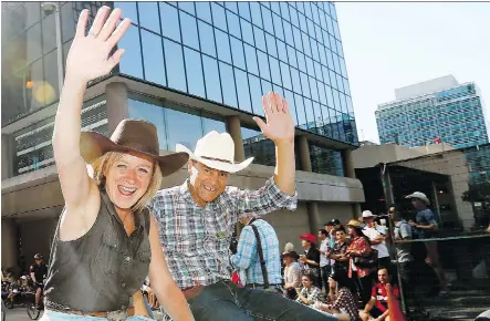  ?? DARREN MAKOWICHUK ?? Premier Rachel Notley and Finance Minister Joe Ceci wave as thousands came out to watch the 105th Stampede Parade in the city’s downtown to kick off The Greatest Outdoor Show on Earth on Friday. The government received mixed news about the province’s...