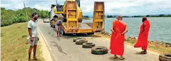  ?? ?? Buddhist monks staging a protest near the Parakrama Samudraya where the government plans to build a ‘walking path’ which critics will harm the bund of the resovior