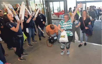  ?? MIKE DE SISTI / MILWAUKEE JOURNAL SENTINEL ?? Above: Patricia Gieringer of Menomonee Falls celebrates and employees cheer as she enters Ikea on Wednesday morning with her friend Shanna Bremer (right), also of Menomonee Falls.