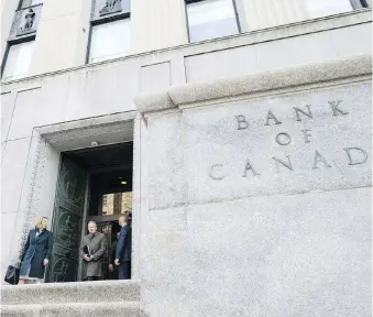  ?? JUSTIN TANG/BLOOMBERG ?? Bank of Canada governor Stephen Poloz, centre, and senior deputy governor Carolyn Wilkins leave the Bank of Canada building for a press conference in Ottawa last Wednesday. There is more money to be made jumping off the Bank of Canada bandwagon after investors worried about aggressive rate hikes hit the sell button, writes Martin Pelletier.