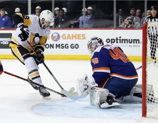  ?? Bruce Bennett / Getty Images ?? New York Islanders goalie Semyon Varlamov makes a stop on Alex Galchenyuk in the Penguins’ 4-3 overtime win Thursday in Brooklyn. “I’m generating more chances, which is a positive sign,” said Galchenyuk, who remains scoreless with the Penguins.