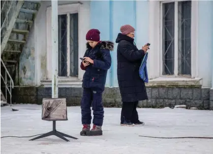  ?? Russia’s invasion. Photograph: Reuters ?? Local residents use a Starlink terminal in Chasiv Yar, Donetsk region, Ukraine in 2023. The technology was rushed in to help Ukraine after