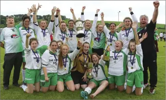  ??  ?? The Cloughbawn squad with the Michelle Coleman Cup after their extra-time triumph.