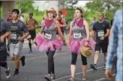  ?? AMERICAN-STATESMAN 2016 ?? Christy Sedtal, left, and Kimberly Calton keep it moving in pink tutus and cowgirl hats during the 39th Austin American-Statesman Cap 10K race April 10, 2016.