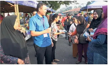  ??  ?? Sibling solidarity: Saiful and Saidati (on his left) during a walkabout at the Bagan Pinang market. — Bernama