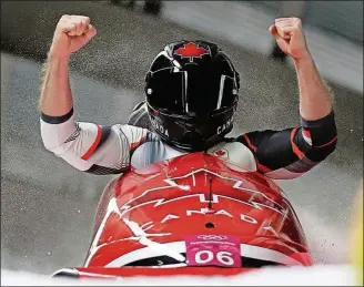  ??  ?? Driver Justin Kripps and Alexander Kopacz of Canada celebrate as they cross the finish area after tying for the gold with Germany during the two-man bobsled final at the Winter Olympics Monday in Pyeongchan­g, South Korea [MICHAEL SOHN/THE ASSOCIATED...